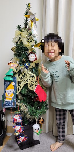 「クリスマスツリーと長男」うちのクリスマスツリーは学校や保育園で作ったものを追加するのでモリモリです。